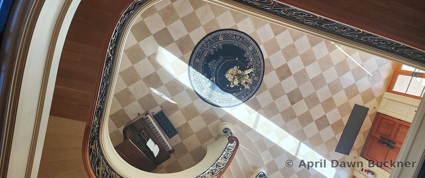Looking straight down at the checkerboard-tile foyer floor, with a round table in the center
